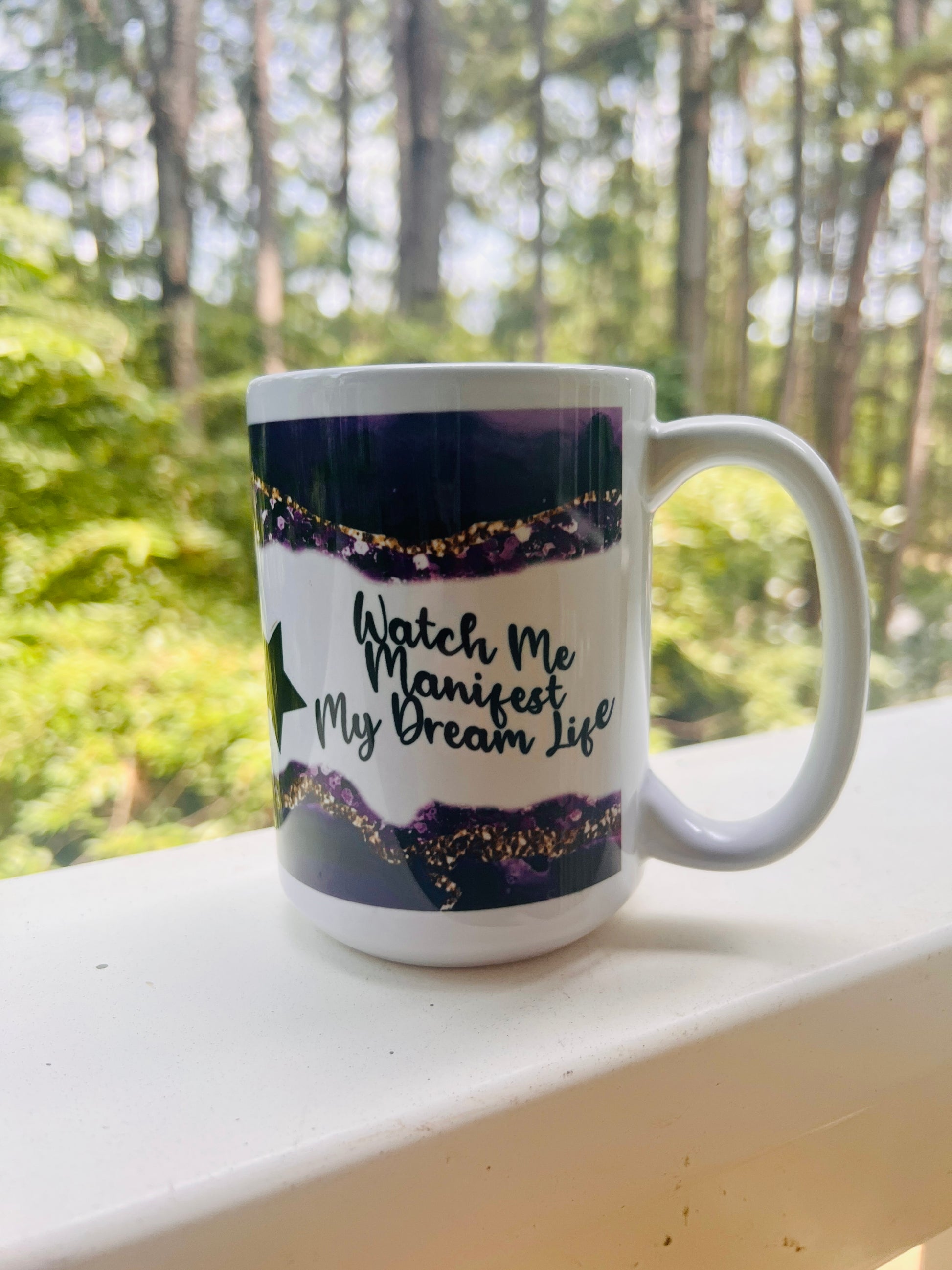 15 oz coffee mug with the quotes: 'Be the extra in the ordinary' on one side and 'Watch me Manifest my Dream Life' on the other with a Purple and gold design on top and bottom.