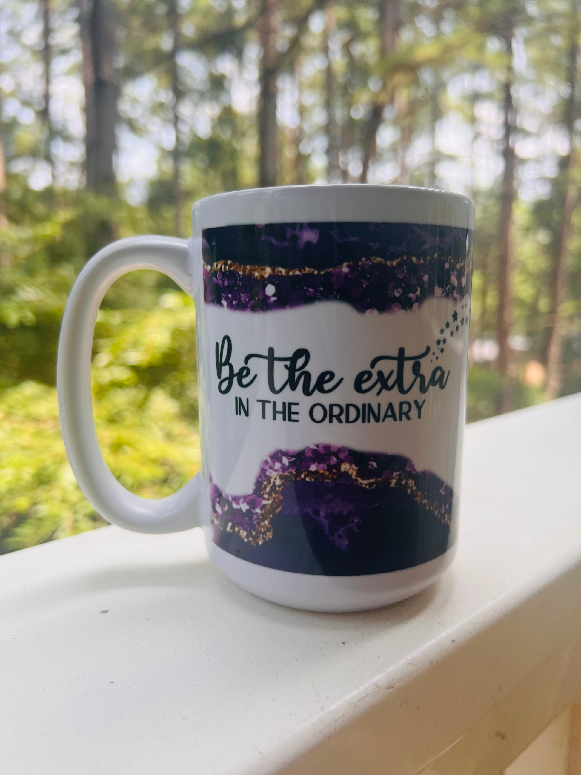 15 oz coffee mug with the quotes: 'Be the extra in the ordinary' on one side and 'Watch me Manifest my Dream Life' on the other with a Purple and gold design on top and bottom..